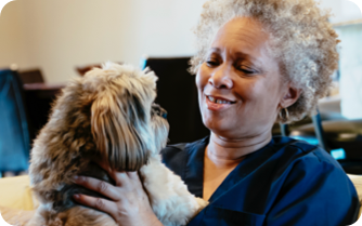 A woman pets her happy dog